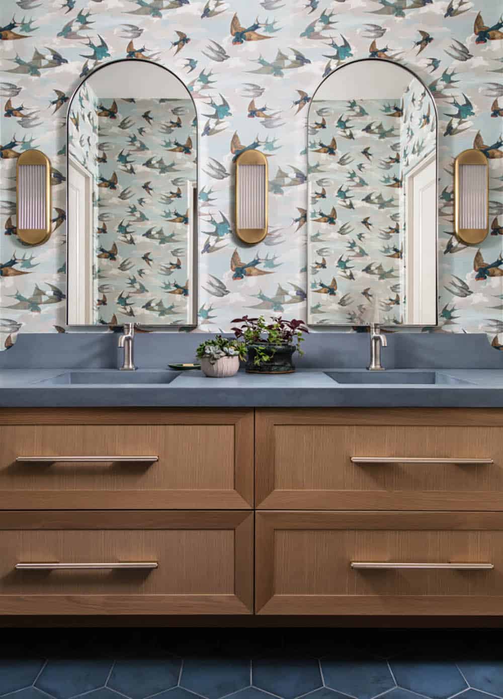 Bathroom with bird print wallpaper and dual arched mirrors