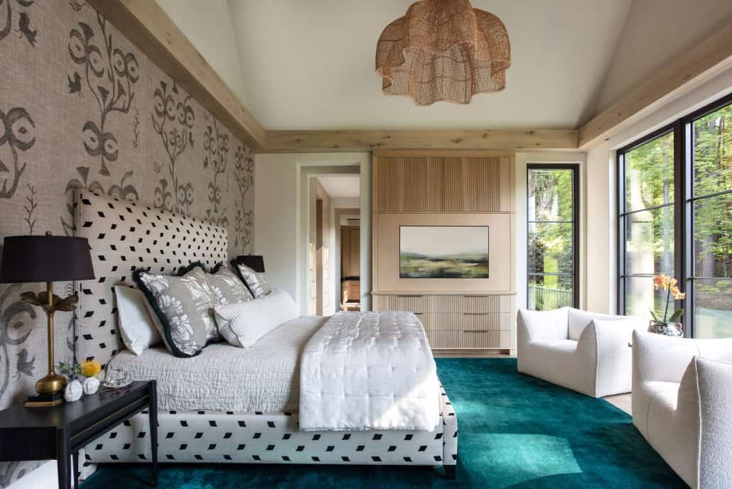 Bedroom with patterned wallpaper and teal area rug