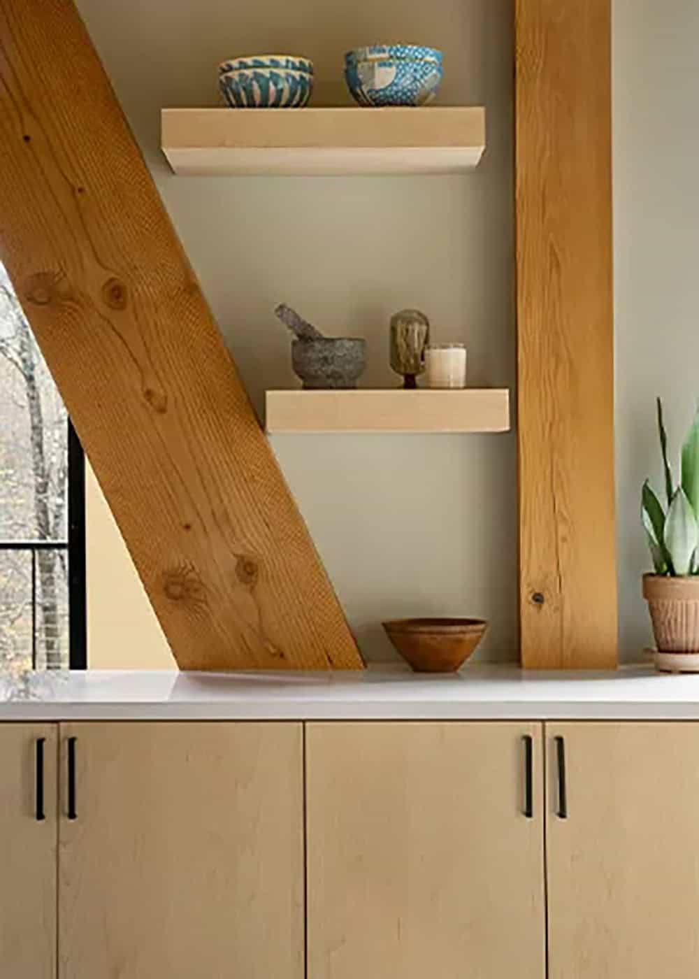 Two floating wood shelves with blue patterned bowls set between a diagonal timber brace and a timber post
