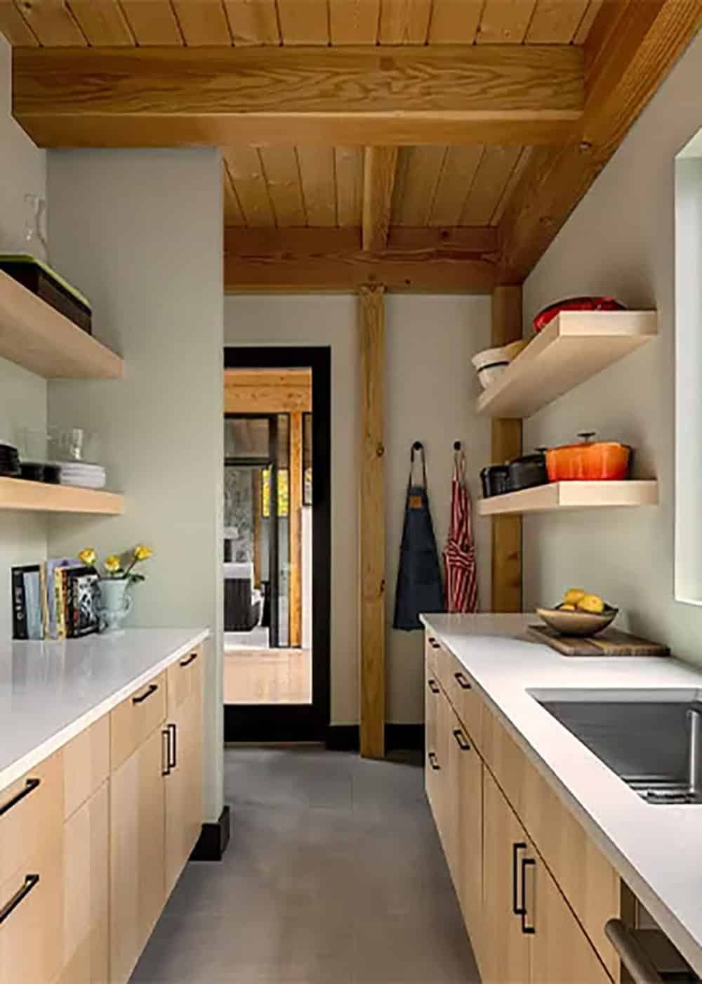 Butler's pantry with light wood cabinets, white countertops, floating shelves and a doorway framed in black