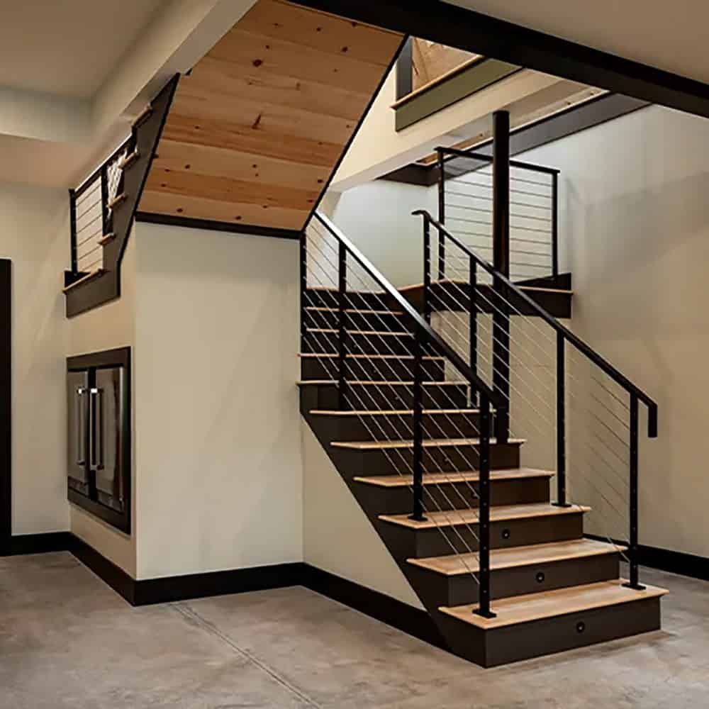 Lower-level staircase with wood treads and cable railings, with built-in beverage refrigerators beneath the landing