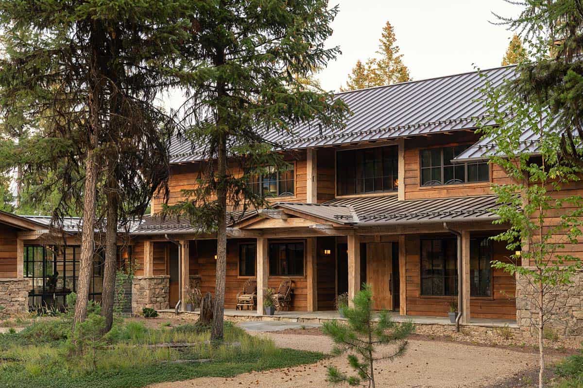 Front porch with reclaimed wood siding, rocking chairs, and timber posts
