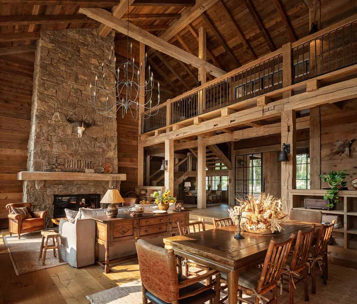 Great room with loft balcony, iron chandelier, and wood dining table