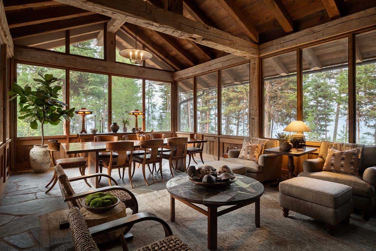 Screened porch with dining table and lounge chairs facing the lake