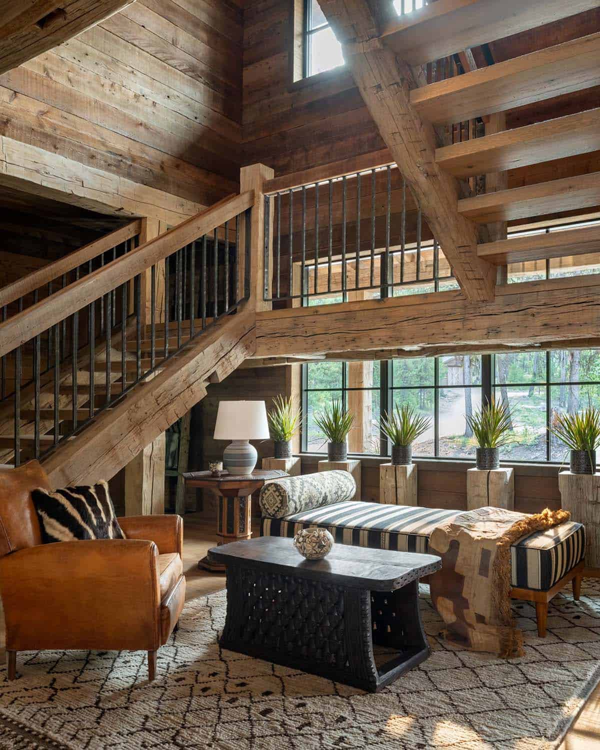 Sitting area beneath the stairs with striped daybed and carved table