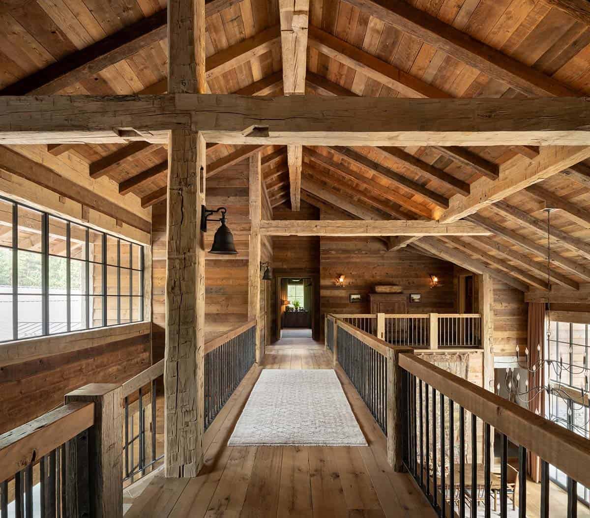 Timber frame loft bridge with iron railings and a cream runner