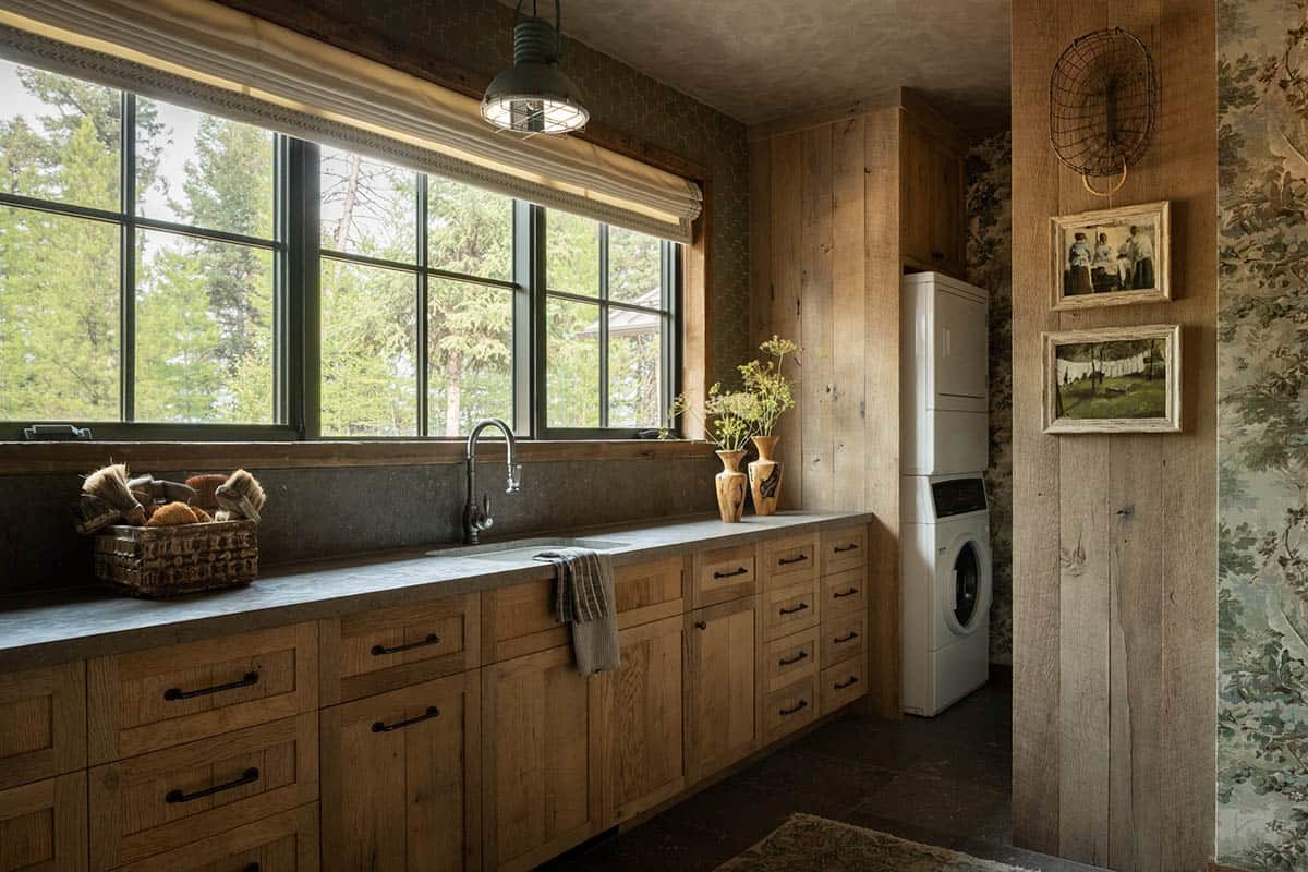 Laundry room with oak cabinets, stone counters, and window over the sink