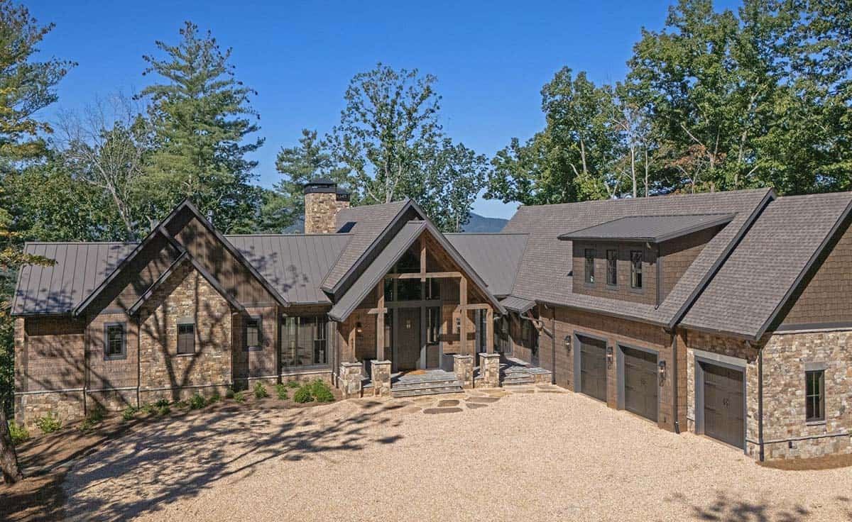 Stone and wood mountain lodge with a timber frame entry porch and gravel motor court