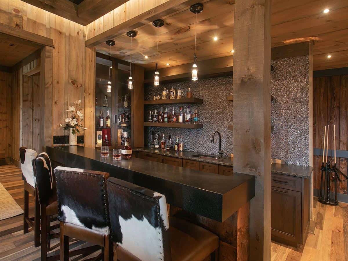 Whiskey bar with cowhide stools, glass display cabinet and mosaic tile backsplash