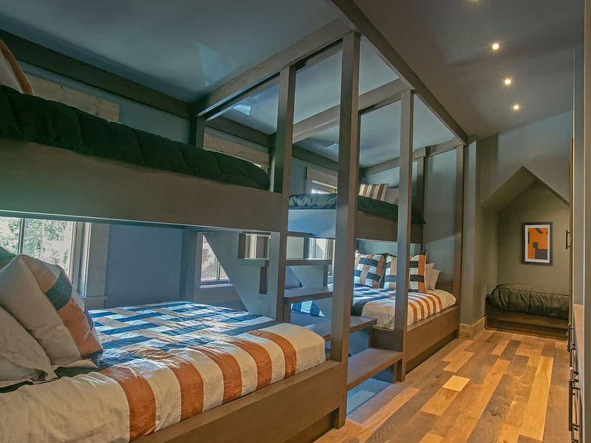 Bunk room with built-in wood bunk beds and striped bedding