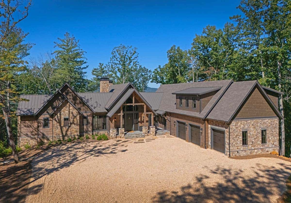 Front of the lodge with stone gables, metal roof and three-car garage