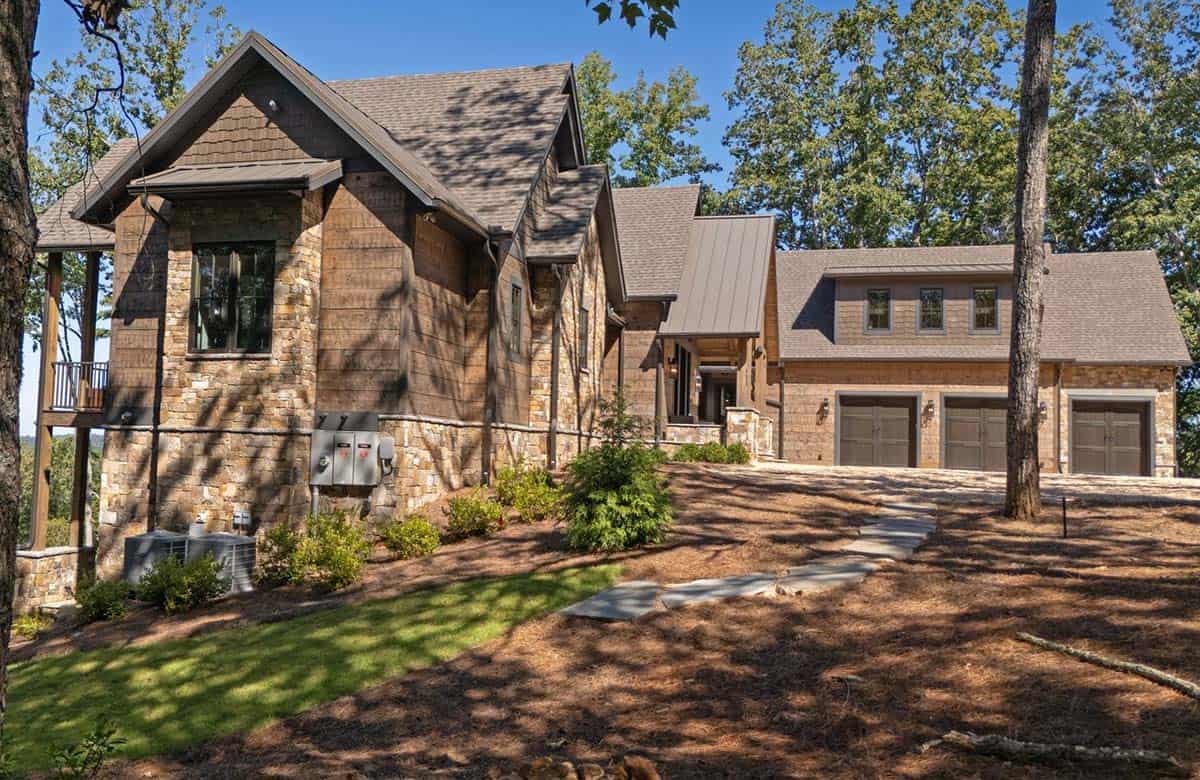Side view of the lodge with stone walls, wood siding and garage