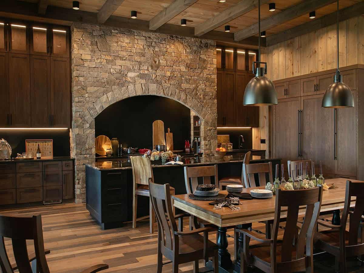Kitchen and dining area with stone stove surround and long wood table