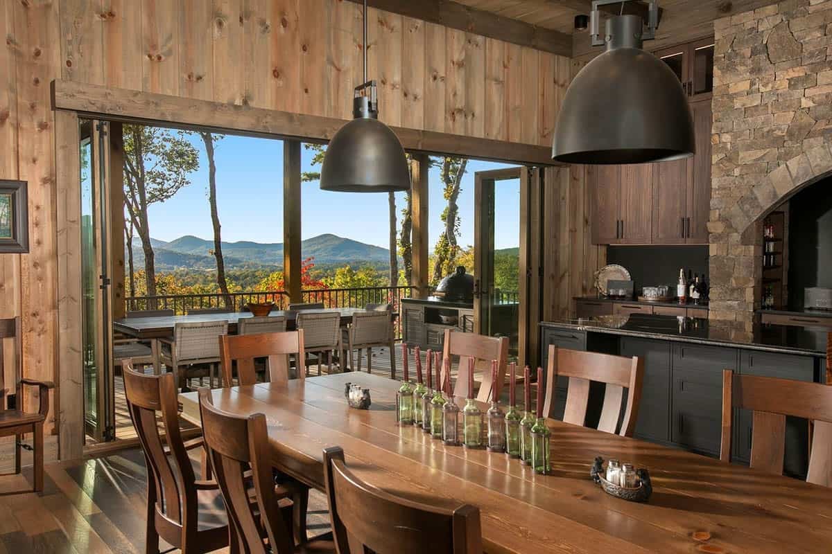 Dining room with folding glass doors open to a porch and mountain views
