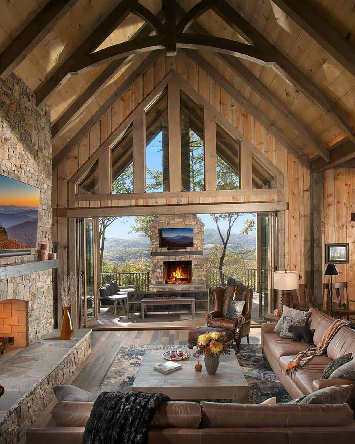 Vaulted great room open to a living porch with a stone fireplace