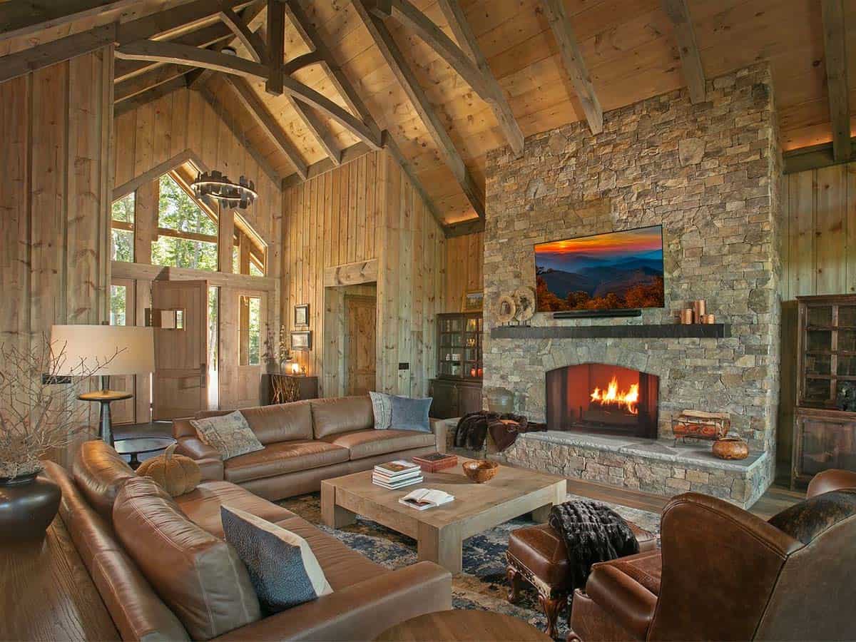 Great room with leather sofas, stone fireplace and vaulted pine ceiling