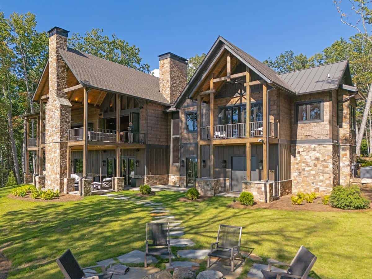 Rear of the lodge with covered porches, stone chimneys and firepit seating