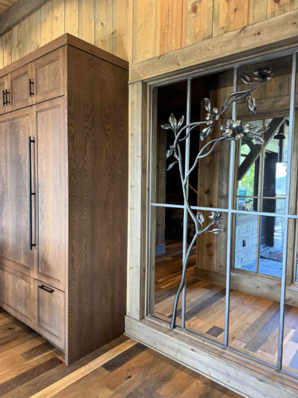 Close-up of the metal dogwood tree divider next to wood paneled cabinetry