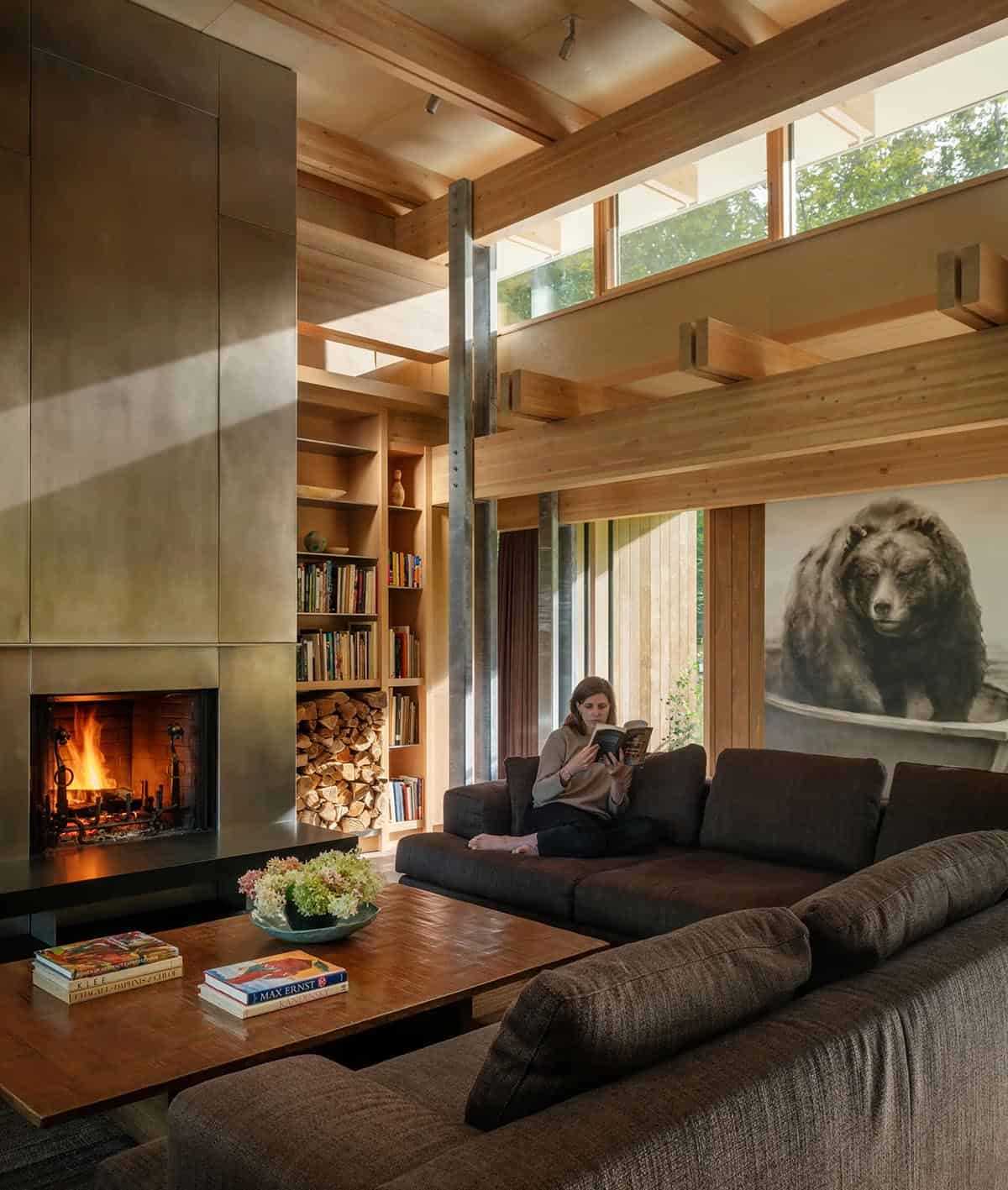 Living room with a steel fireplace, firewood shelves, and a bear painting
