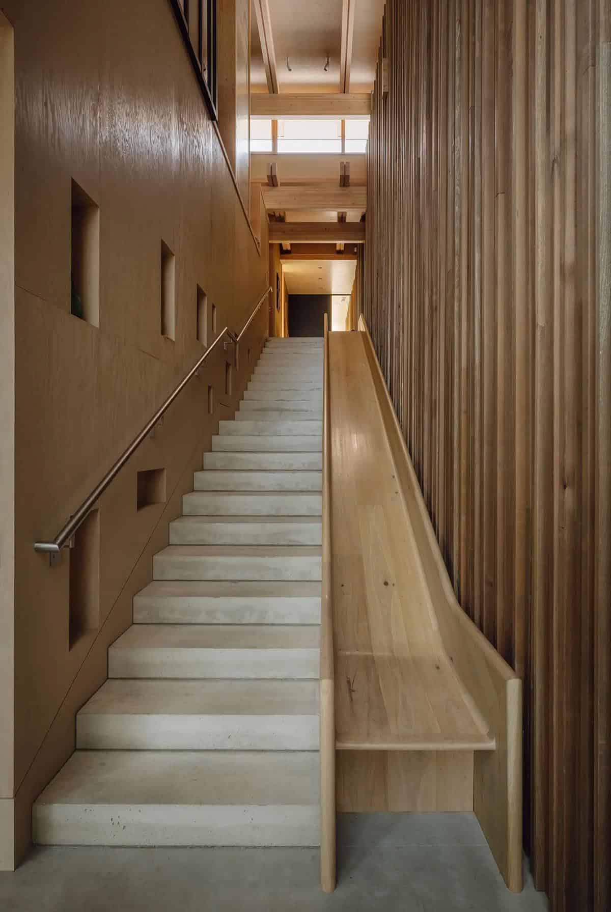 Concrete staircase with a wooden slide alongside