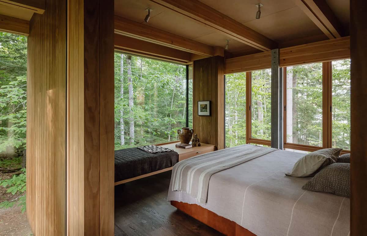 Bedroom with a window daybed and corner windows facing the forest