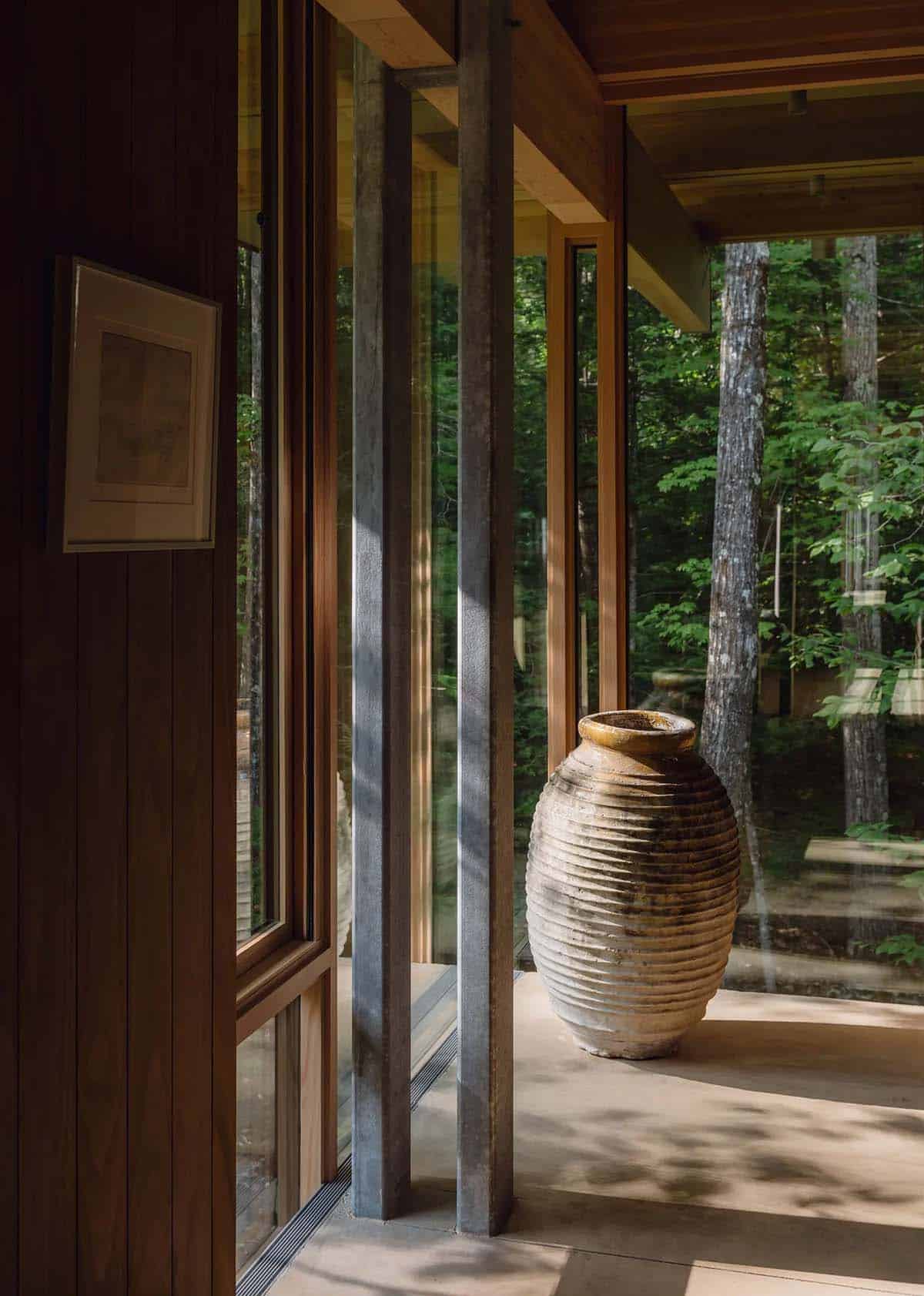 Ribbed clay urn beside galvanized steel columns and a glass corner window