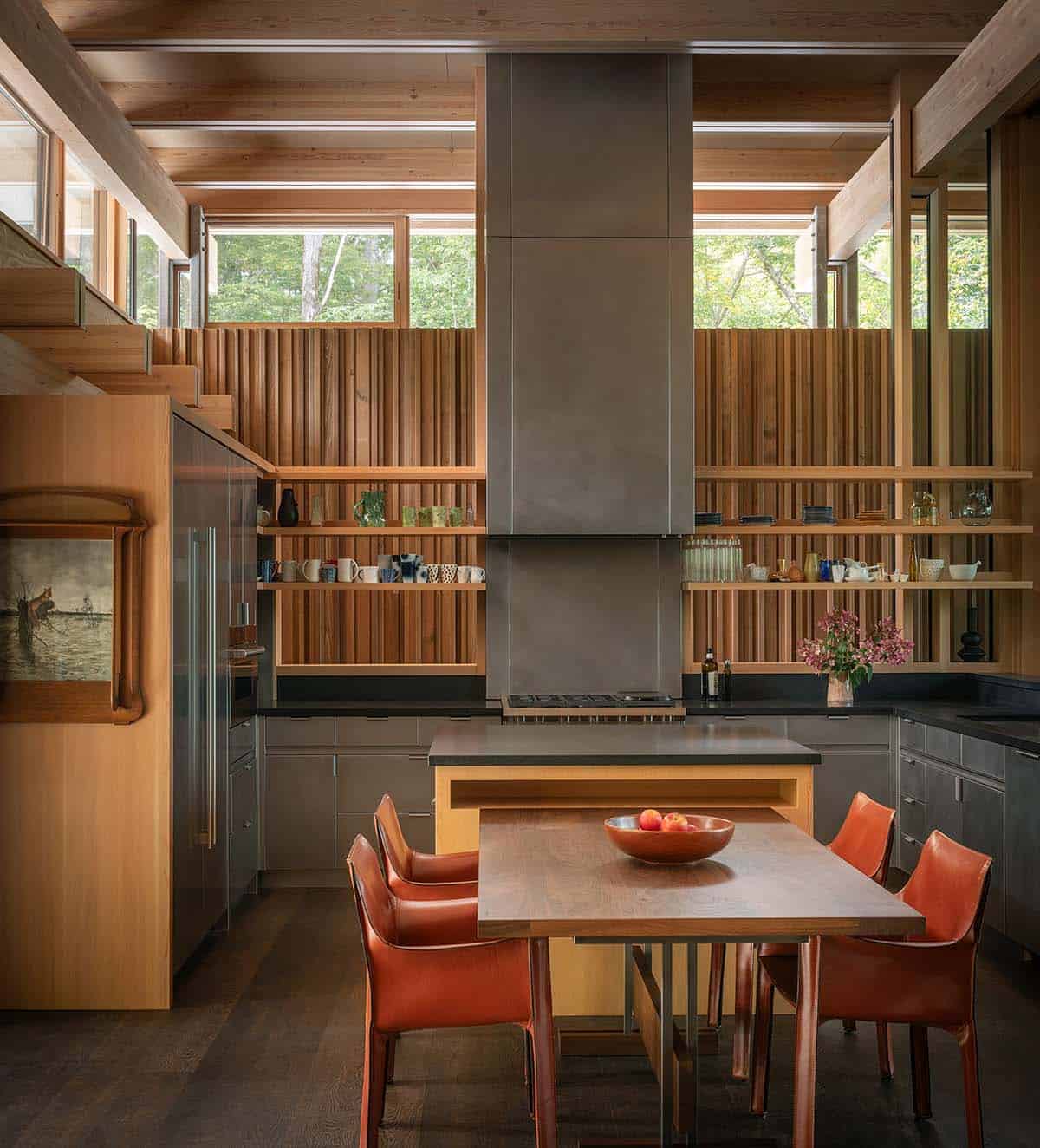 Kitchen with a stainless steel hood, cedar slat wall, and open shelves of dishes