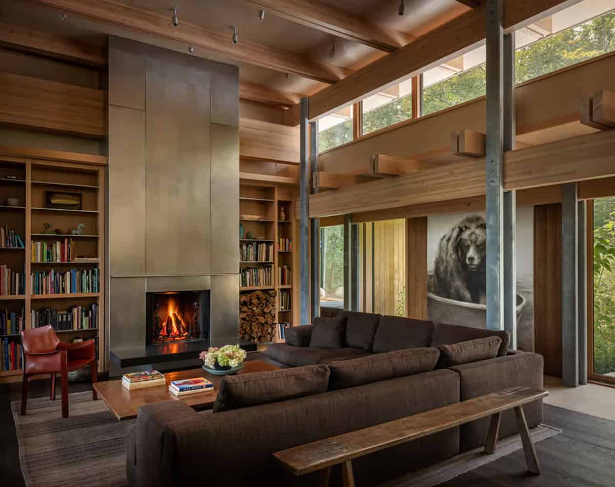 Living room with a steel fireplace, built-in bookshelves, and clerestory windows