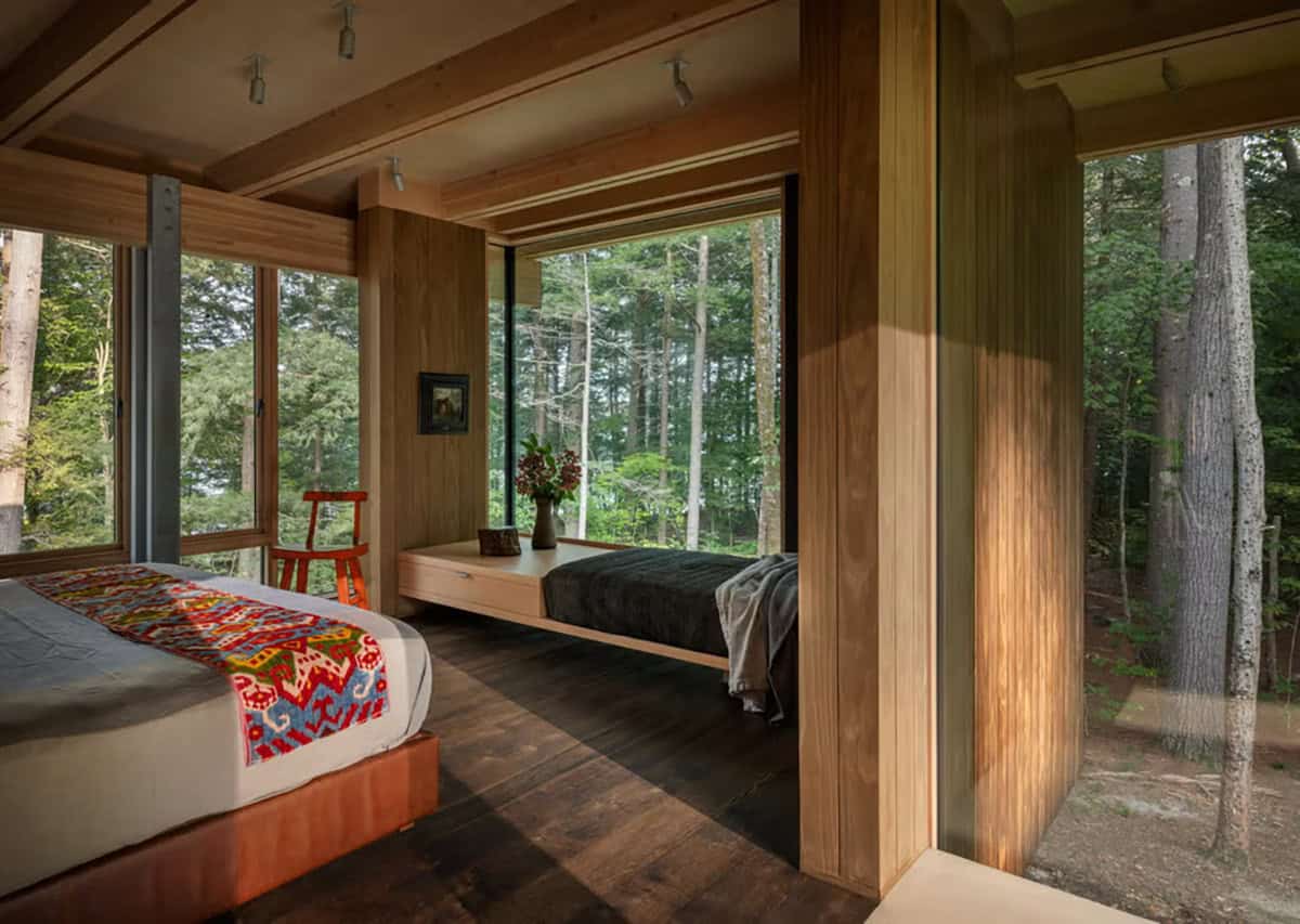 Bedroom with an embroidered bed runner, window daybed, and forest views