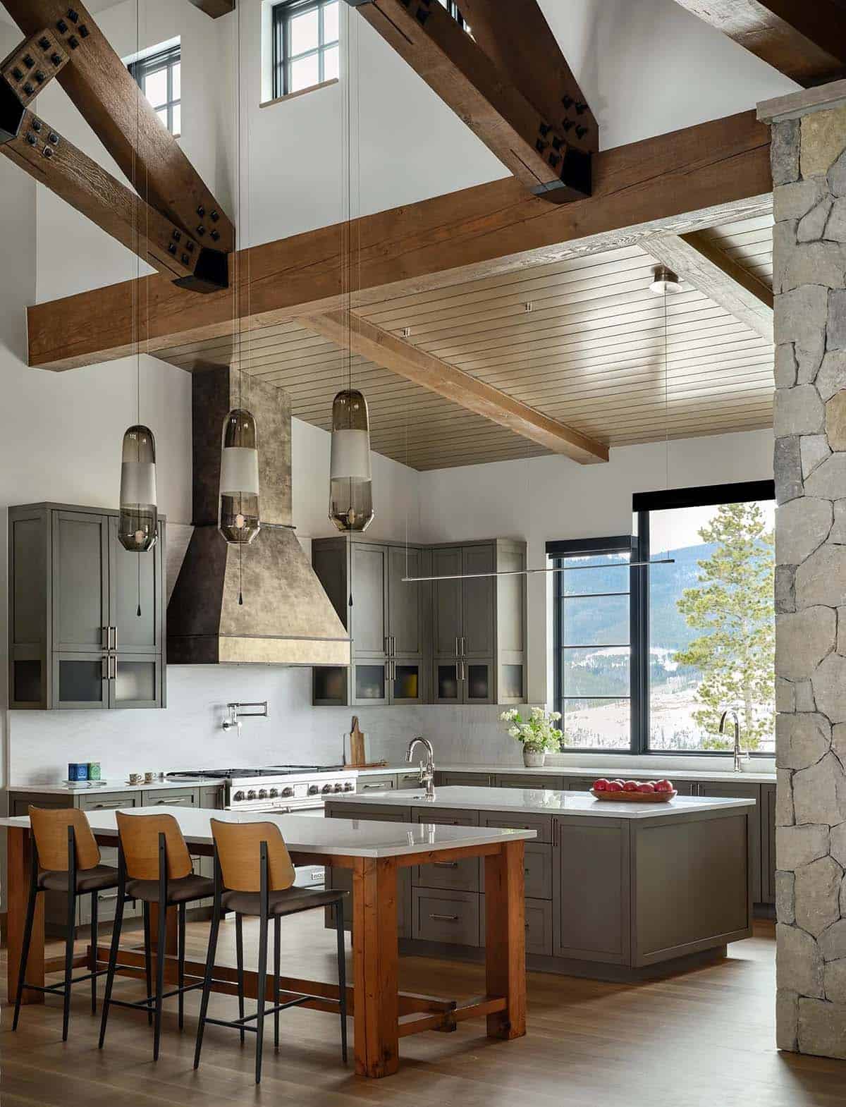 Kitchen with timber beams, glass pendants, and a wood gathering table island