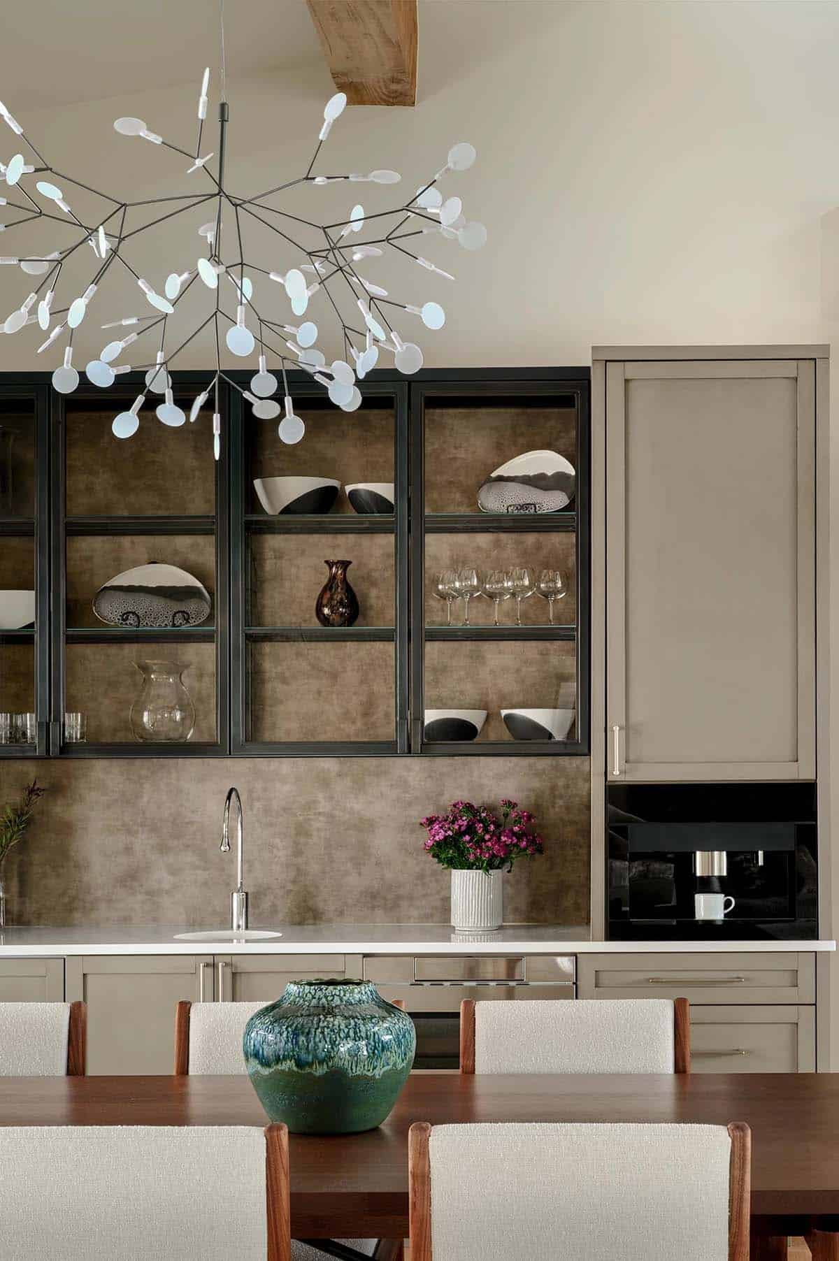 Coffee bar with steel-framed glass cabinets and a branching chandelier