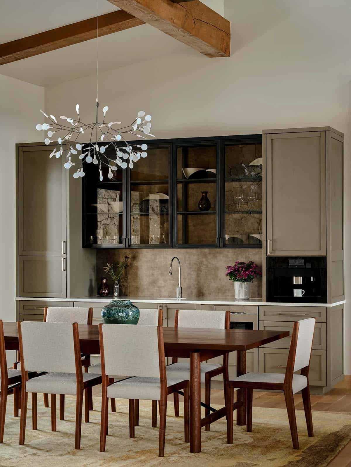 Dining room with walnut table, branching chandelier, and coffee bar