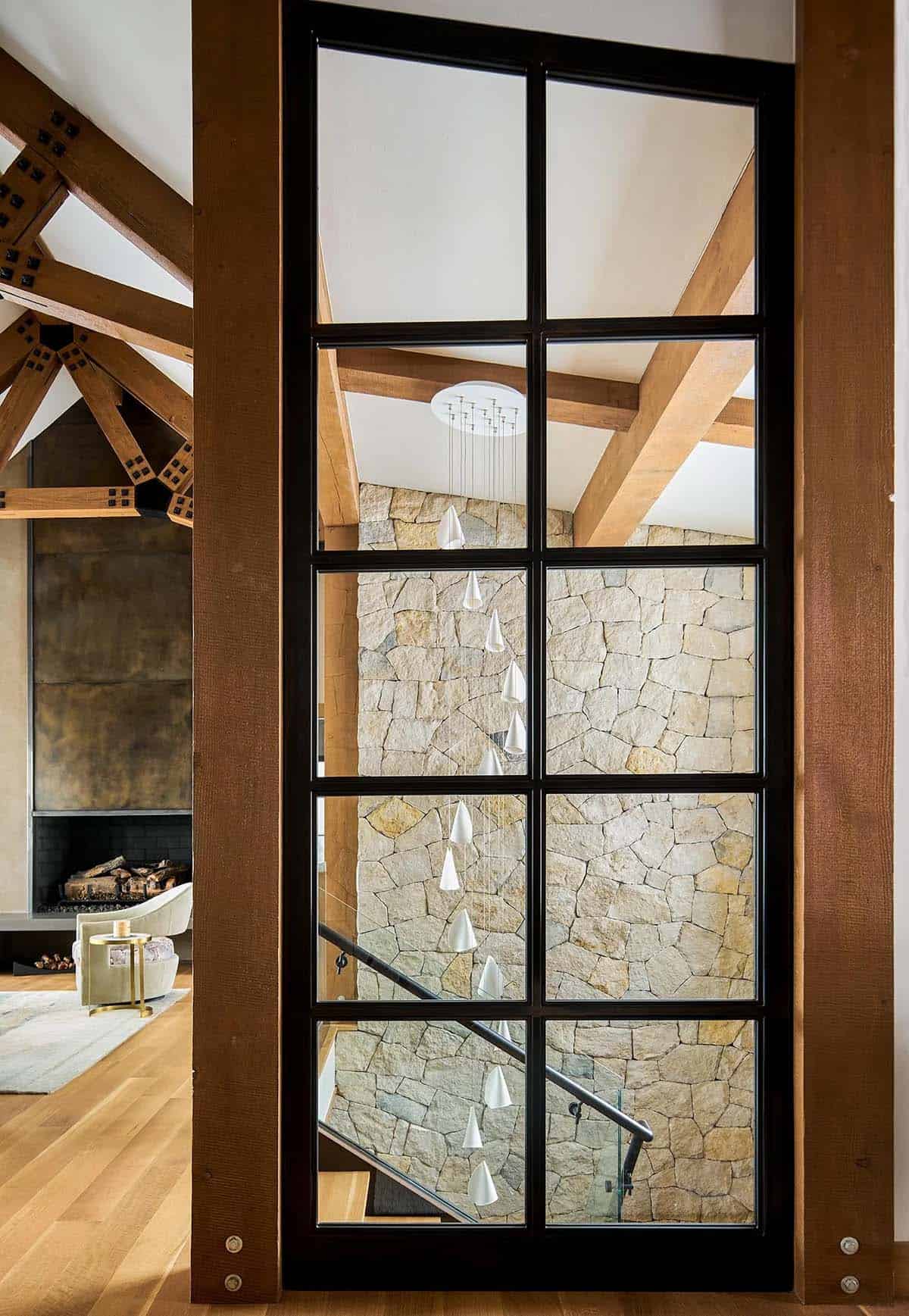 Steel-framed glass wall looking into the stone stairwell