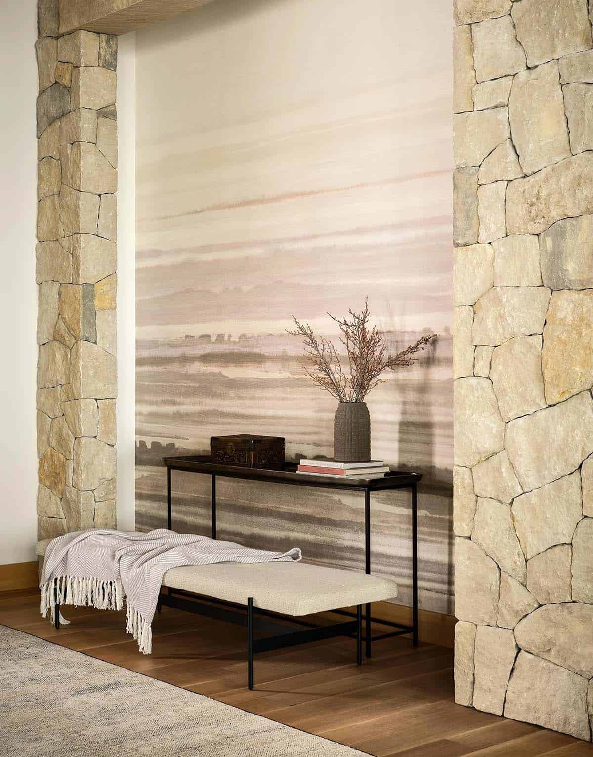 Entry with stone walls, watercolor-style wallpaper, and a black console table