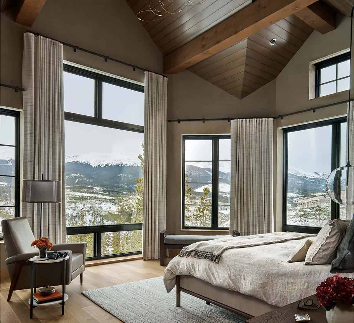 Primary bedroom with vaulted wood ceiling and mountain view windows