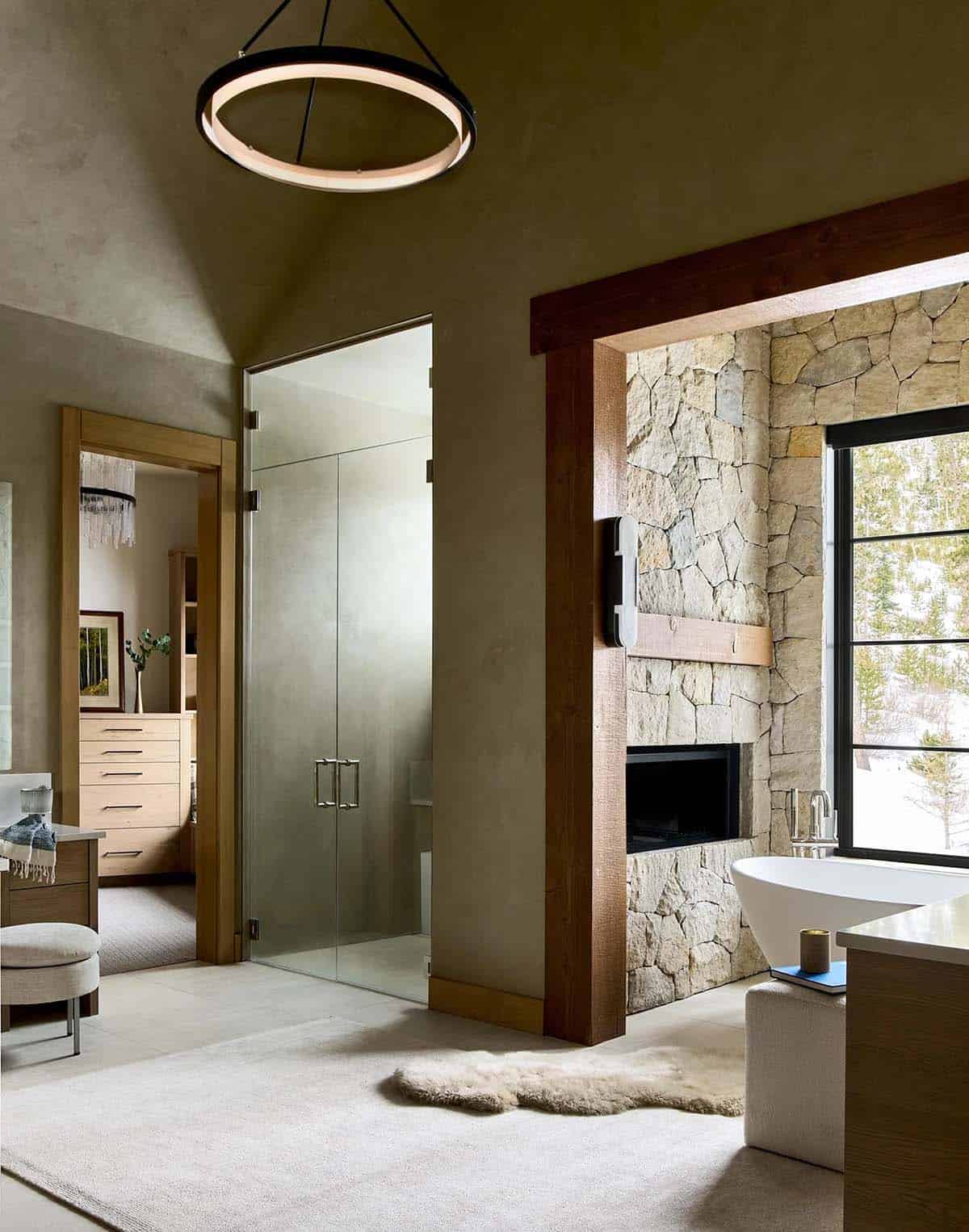 Primary bathroom with plaster walls, glass shower doors, and stone tub alcove