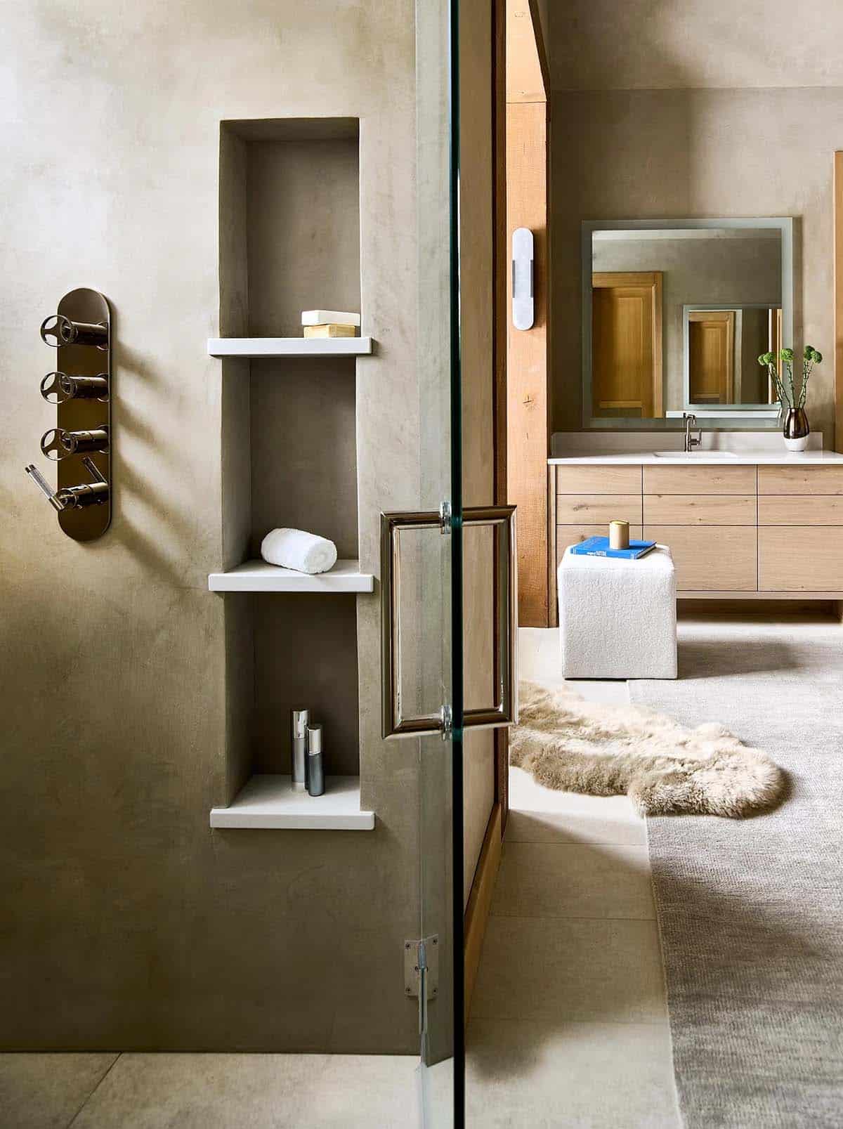 Plaster shower with built-in niche shelves looking toward the vanity