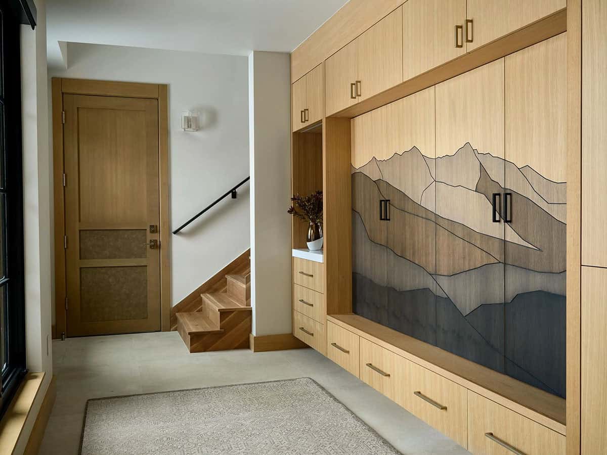 Mudroom with wood cabinets inlaid with a mountain range design