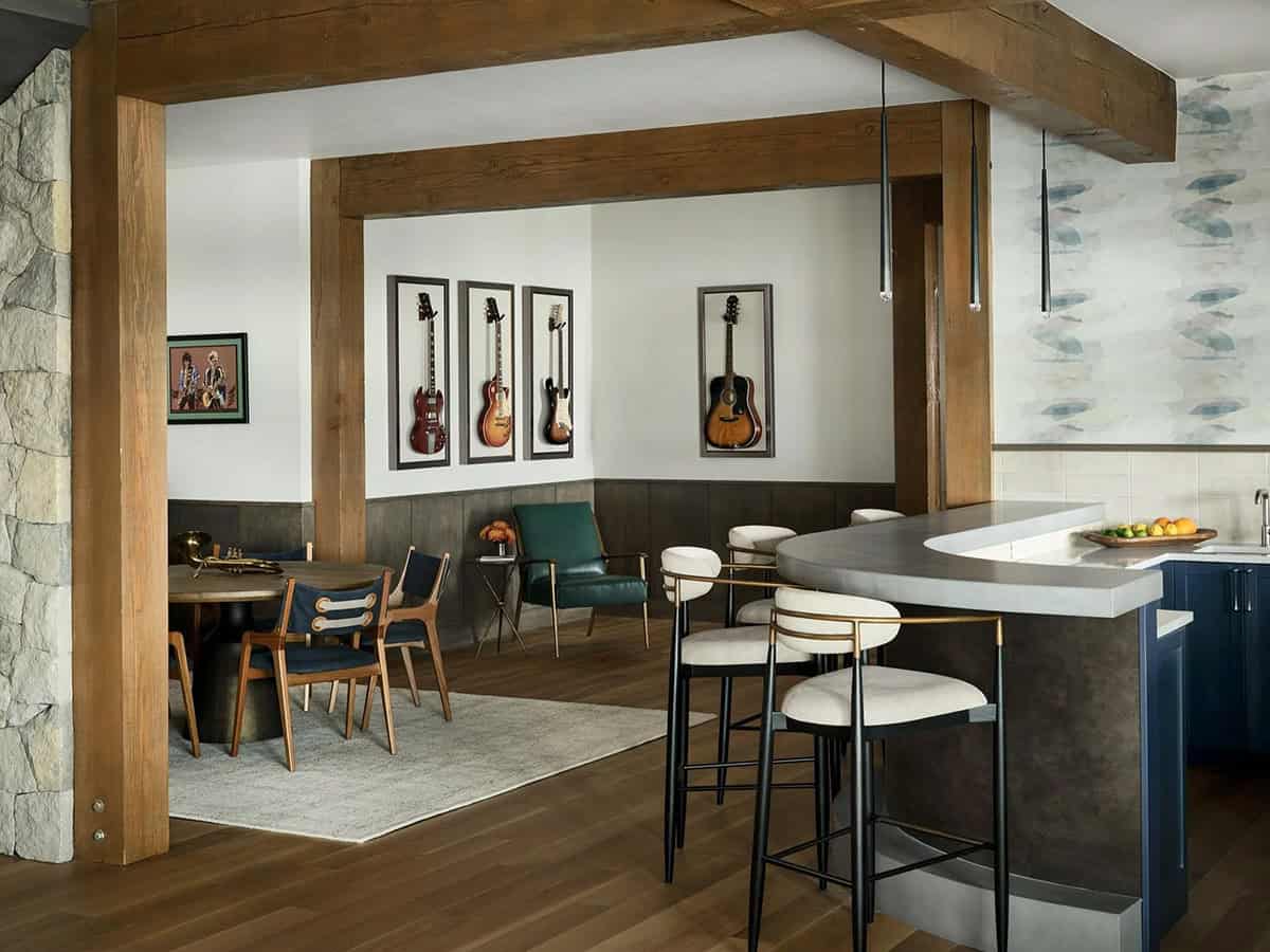 Lower-level bar with a curved counter and framed guitars on the wall