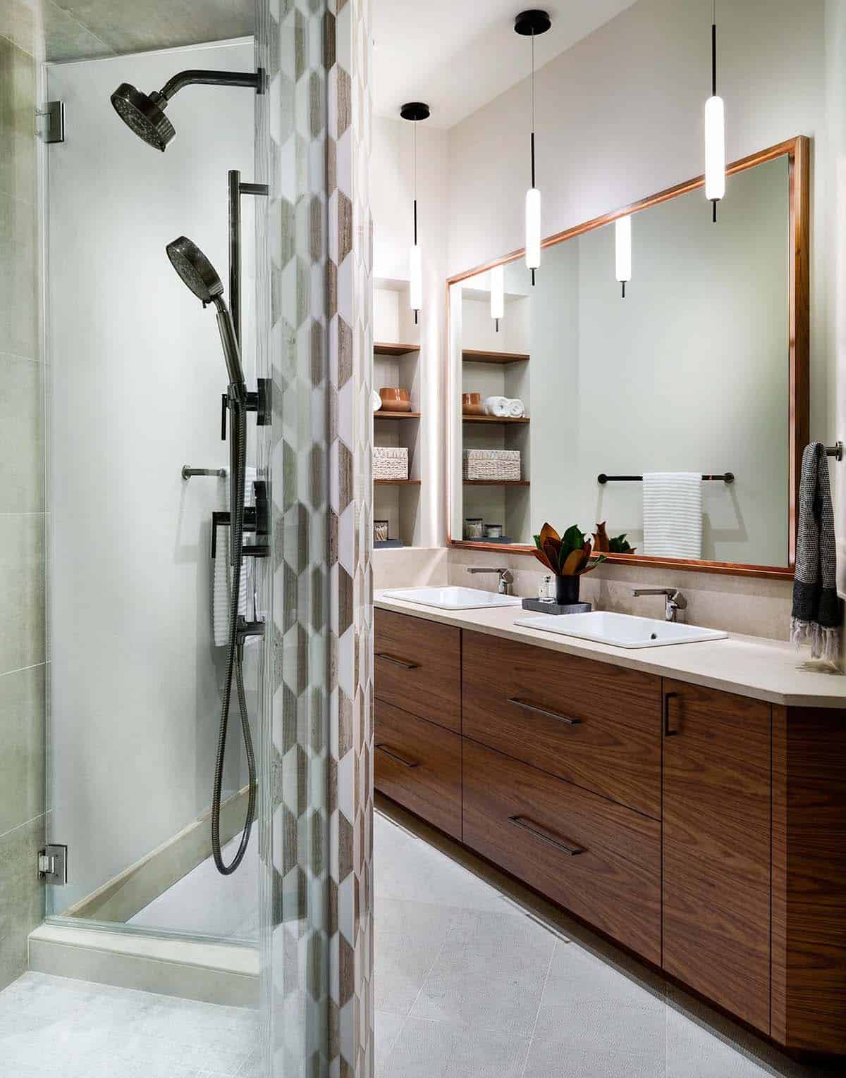 Bathroom with walnut double vanity and a patterned tile shower