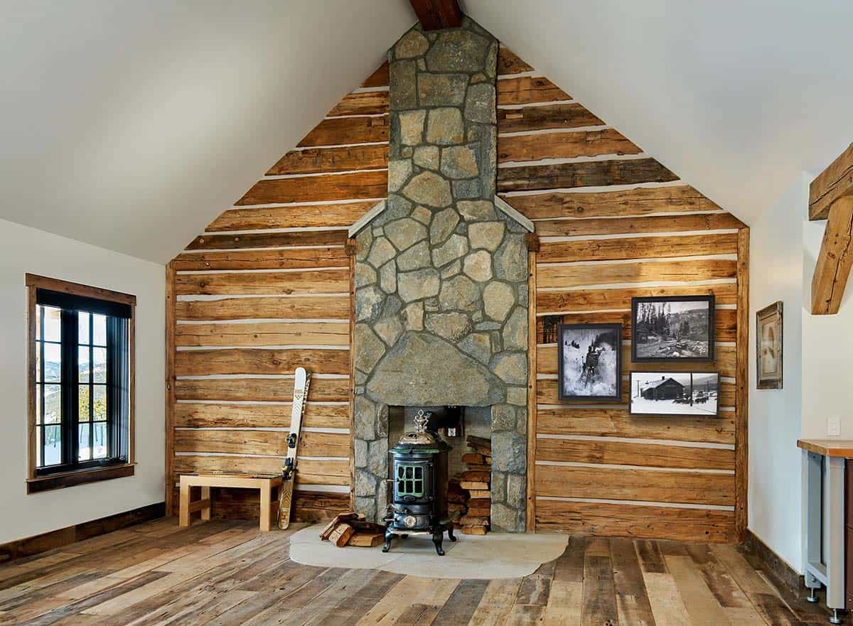 Log cabin room with stone chimney and a vintage woodstove