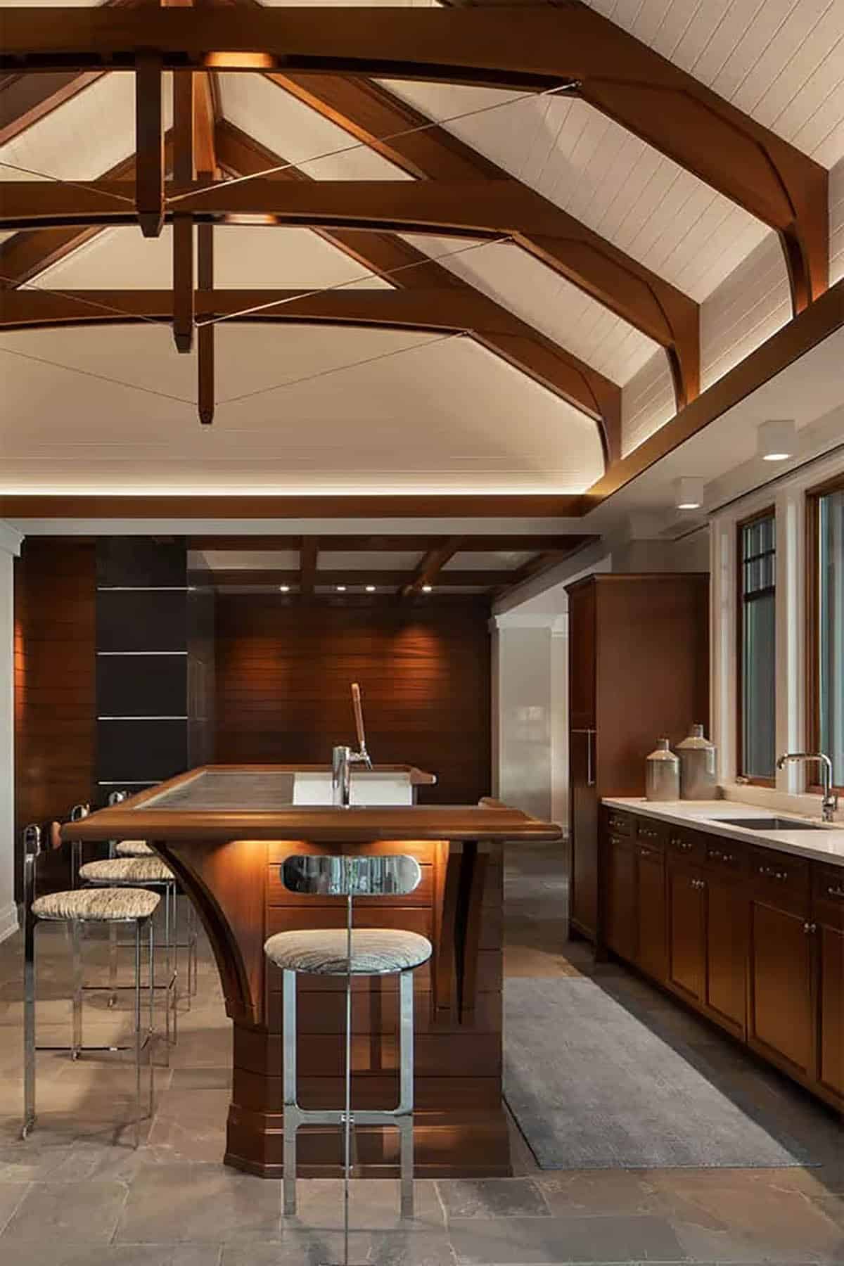 Wood bar island with beer tap under white trussed ceiling