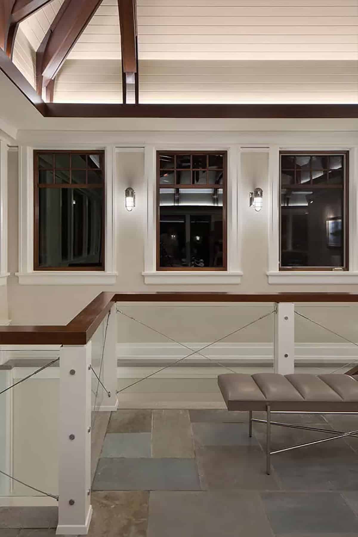 Upper landing with cable railing, stone floor and nautical sconces