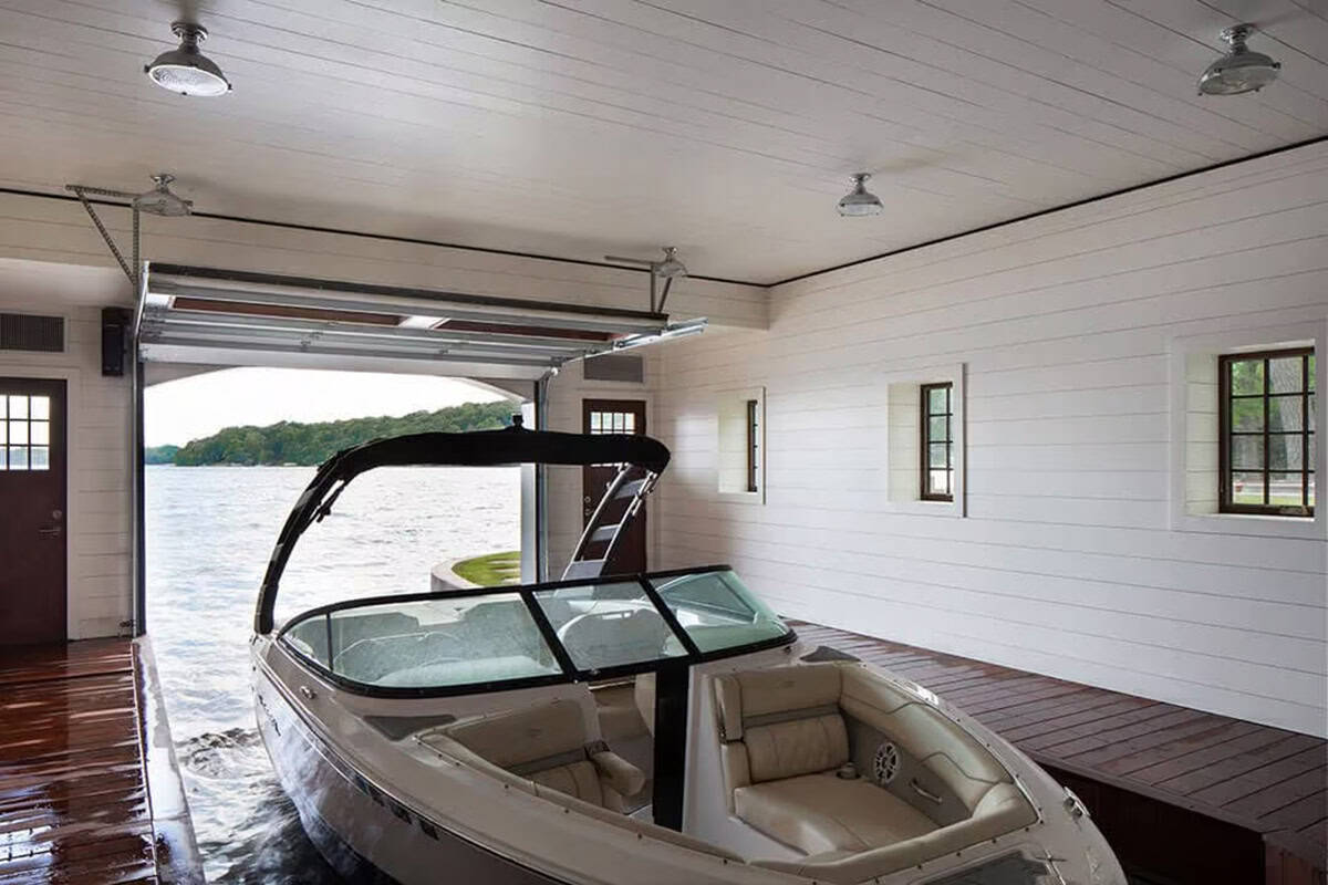 Boat in the slip with the overhead door open to the lake