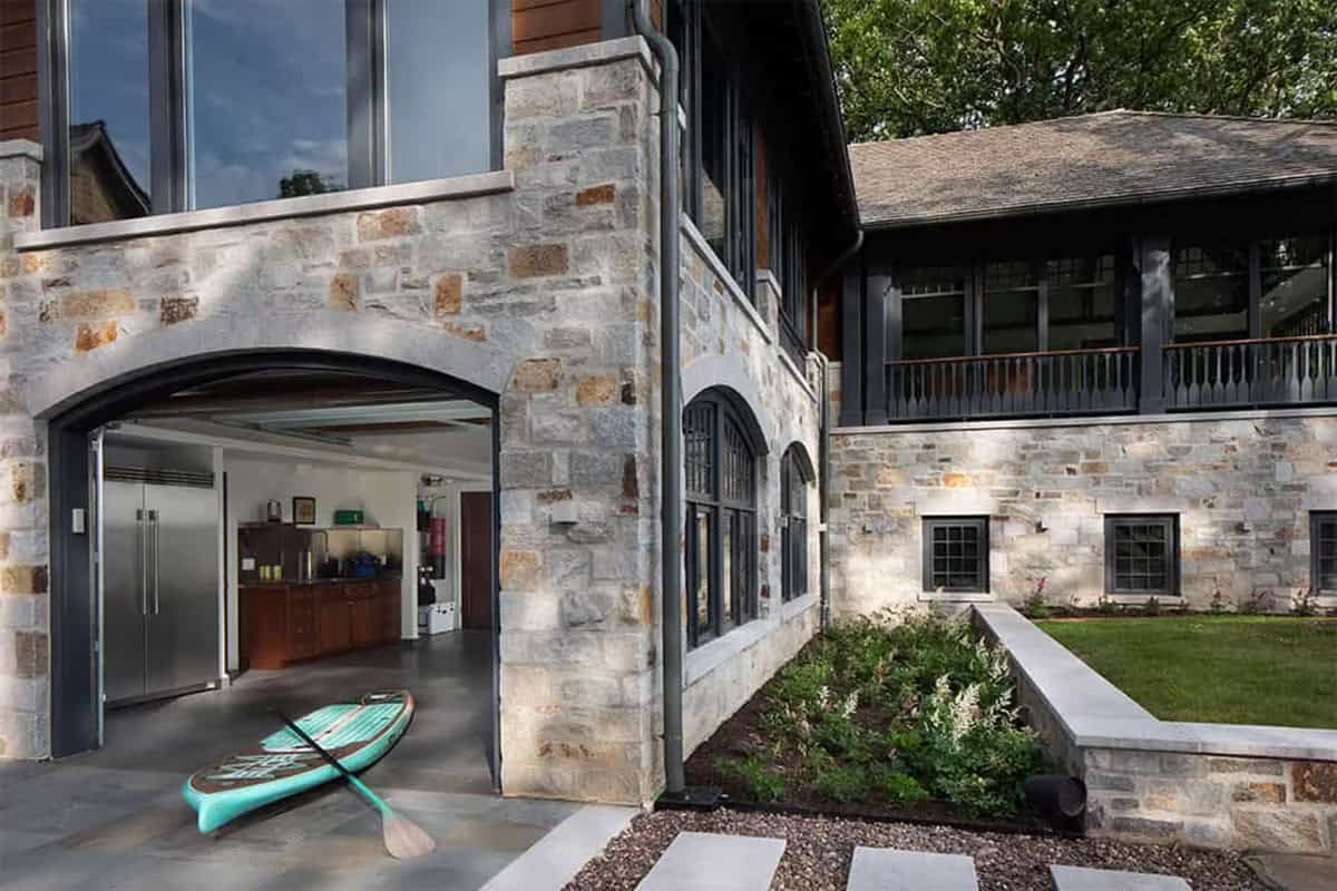 Stone archway opening to boathouse storage with a paddleboard