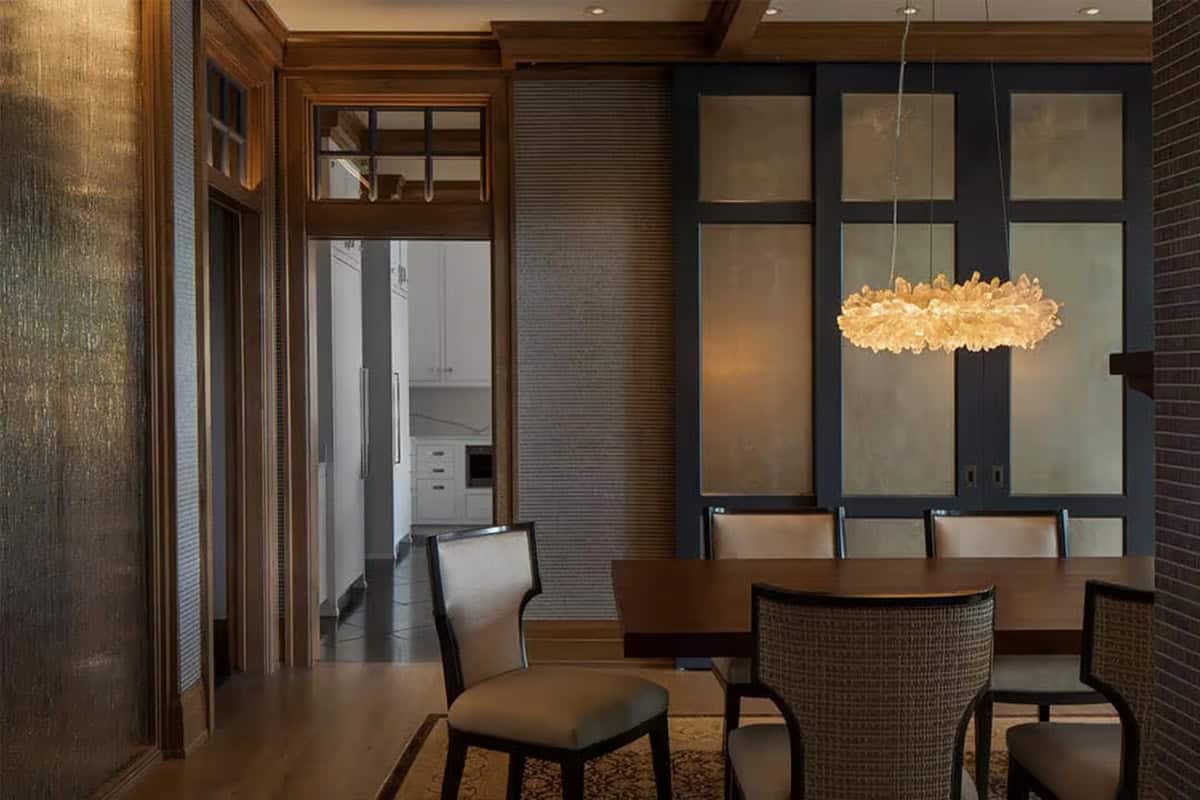Dining room with crystal chandelier and closed silver gilded sliding panels