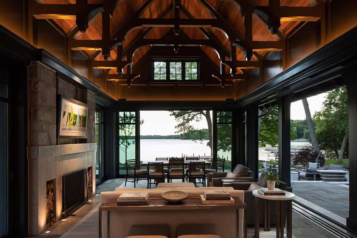 Lake pavilion with glass walls folded open to the terrace