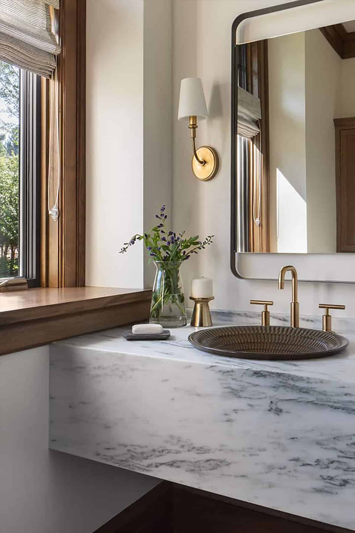 Bathroom vanity with marble countertop and gold faucets