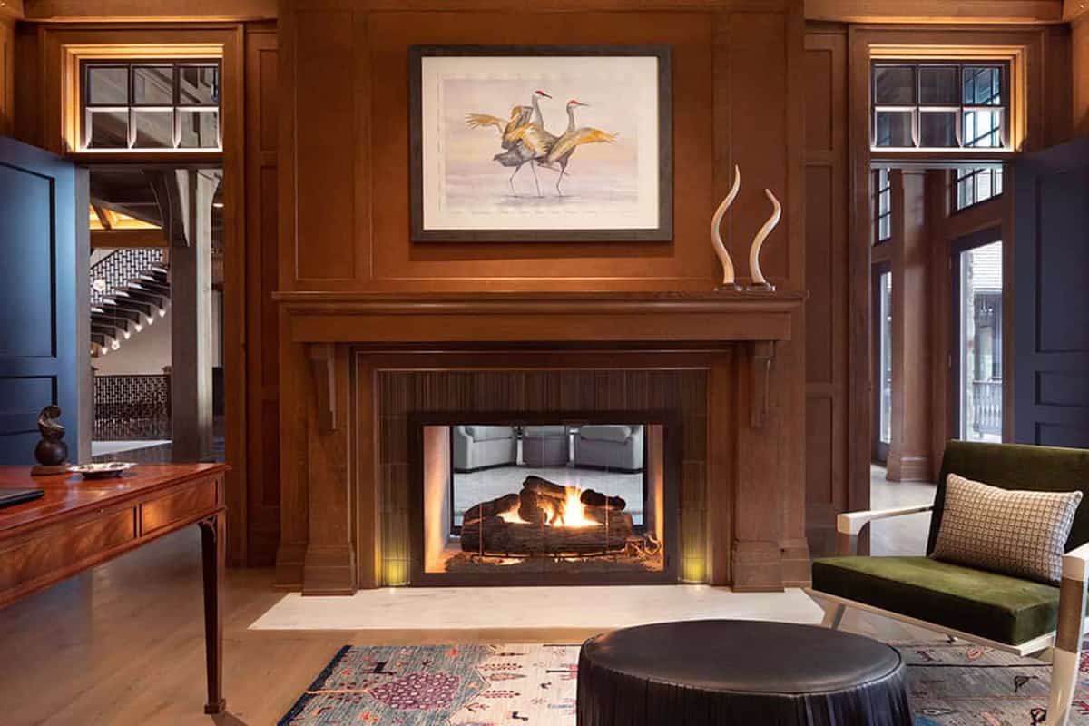 Paneled library with double-sided fireplace and crane artwork