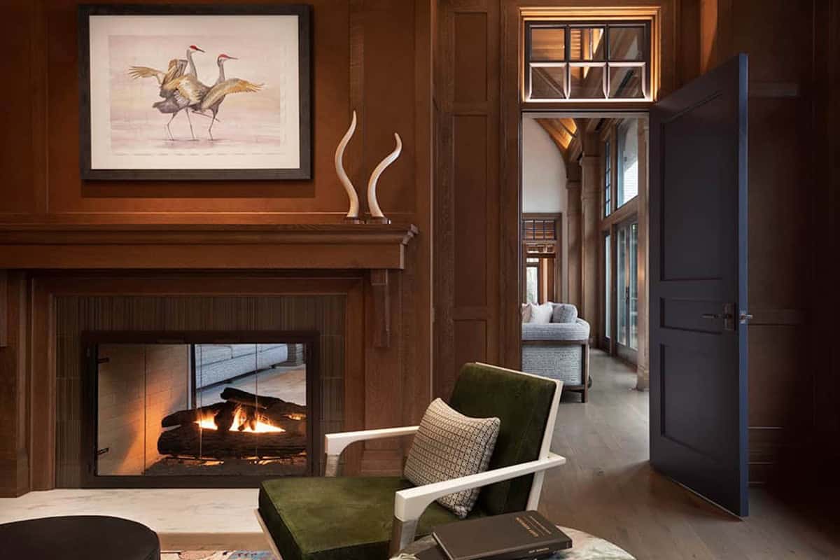 Library fireplace with green velvet chair and navy door